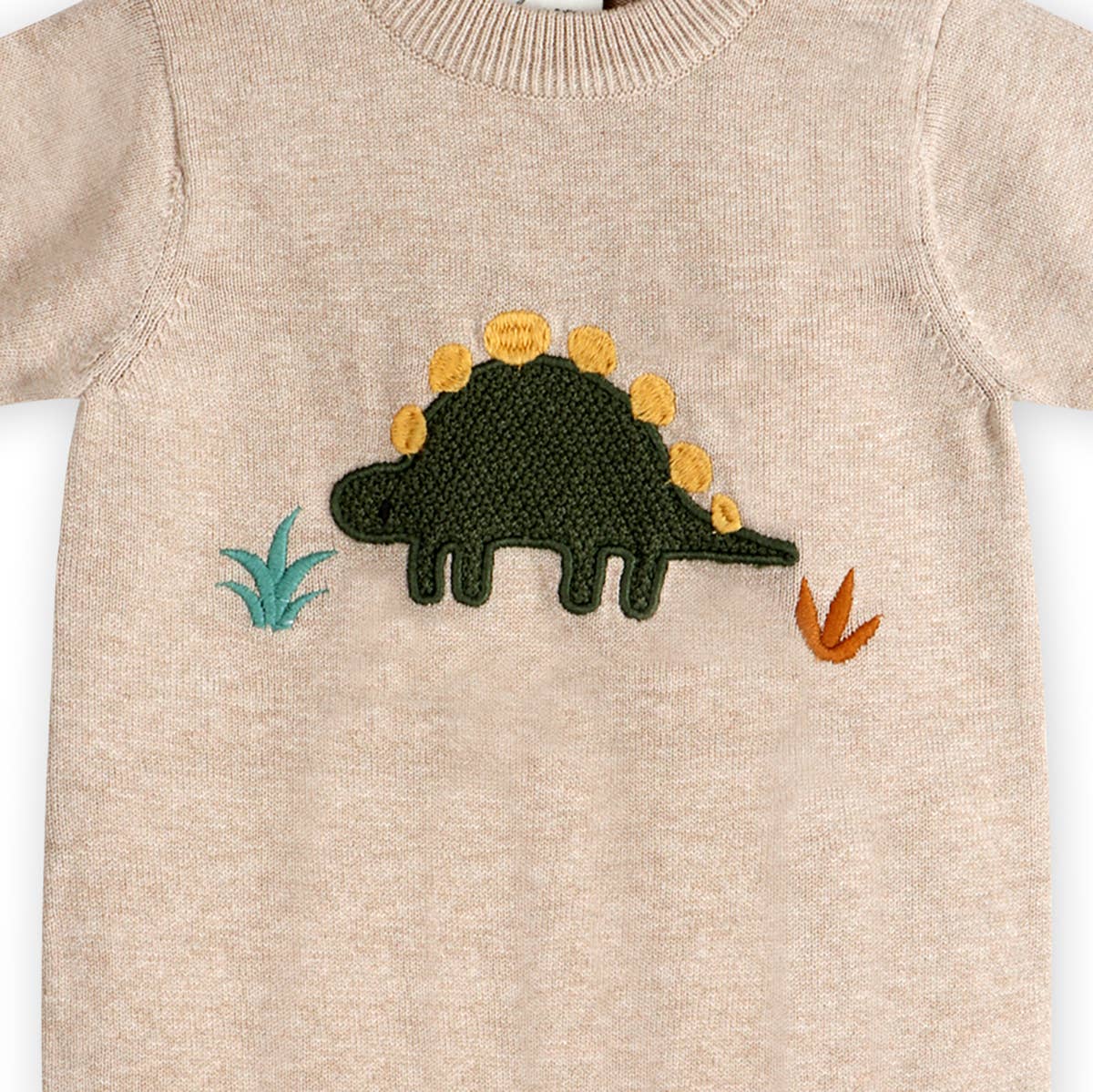 Beige sweater with a dinosaur patch on a white background