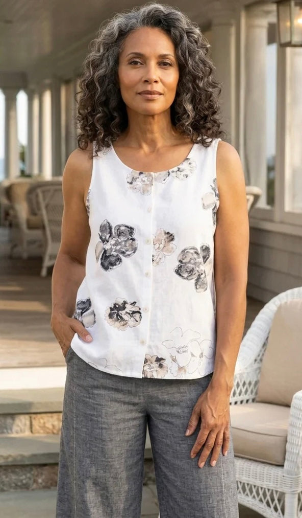 Front view (white background) — "Habitat Women's Linen Floral Print Pleat Back Button Tank in white with navy and taupe watercolor floral print, front view, smiling curly-haired model with hands in pockets, white background"
Back view — "Habitat Women's Linen Floral Print Pleat Back Button Tank in white with navy and taupe watercolor floral print, back view showing pleat detail, styled with grey linen trousers"
Lifestyle front (porch) — "Habitat Women's Linen Floral Print Pleat Back Button Tank in white wit