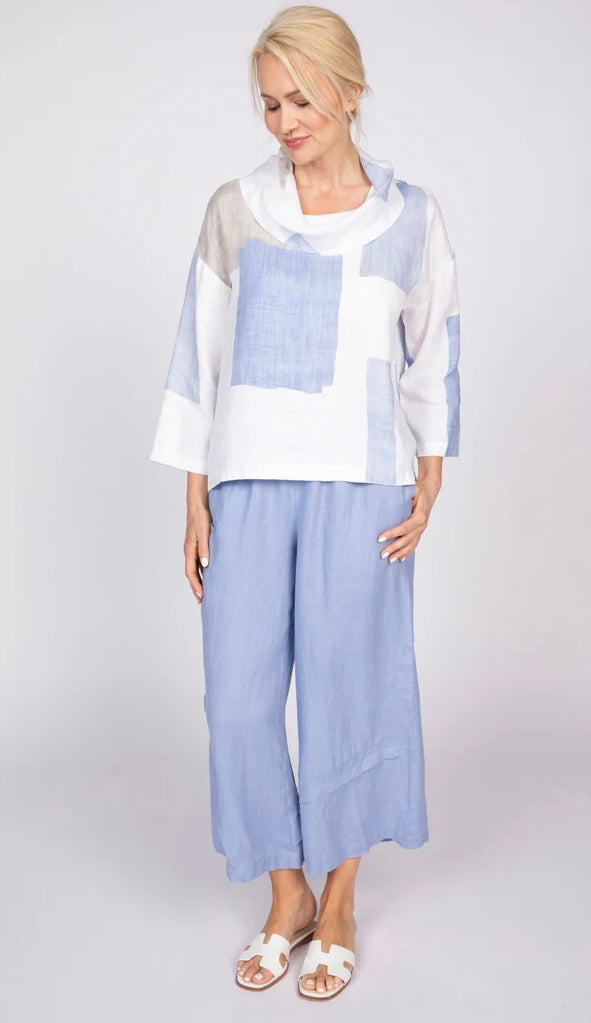 "Woman modeling Olivia by Habitat coastal colorblock linen cowl top in blue, white, and taupe with wide-leg blue pants and white slide sandals, full-body front view"