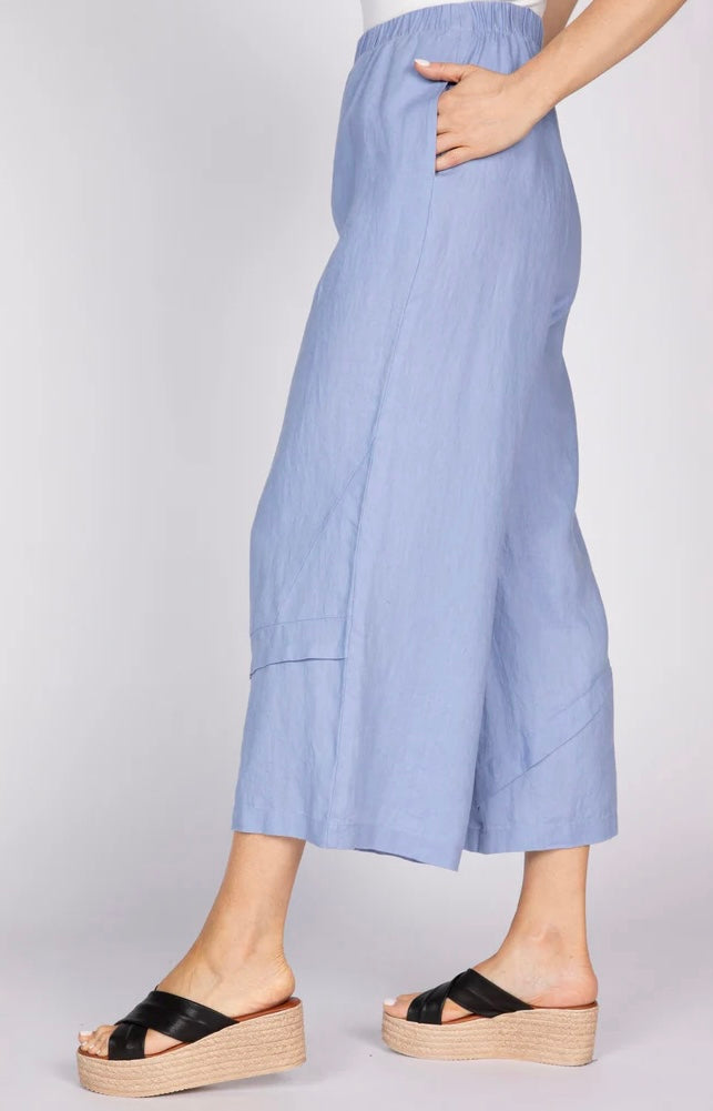"Close side view of Olivia by Habitat Women's Crossroads Seamed Pant in lavender blue linen with hand in pocket, highlighting wide-leg crop and seam detail"