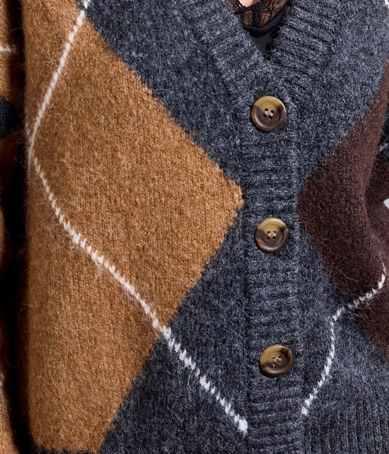 Close-up of a textured knit cardigan featuring a geometric diamond pattern in charcoal gray, camel brown, and dark brown, with three dark brown buttons.