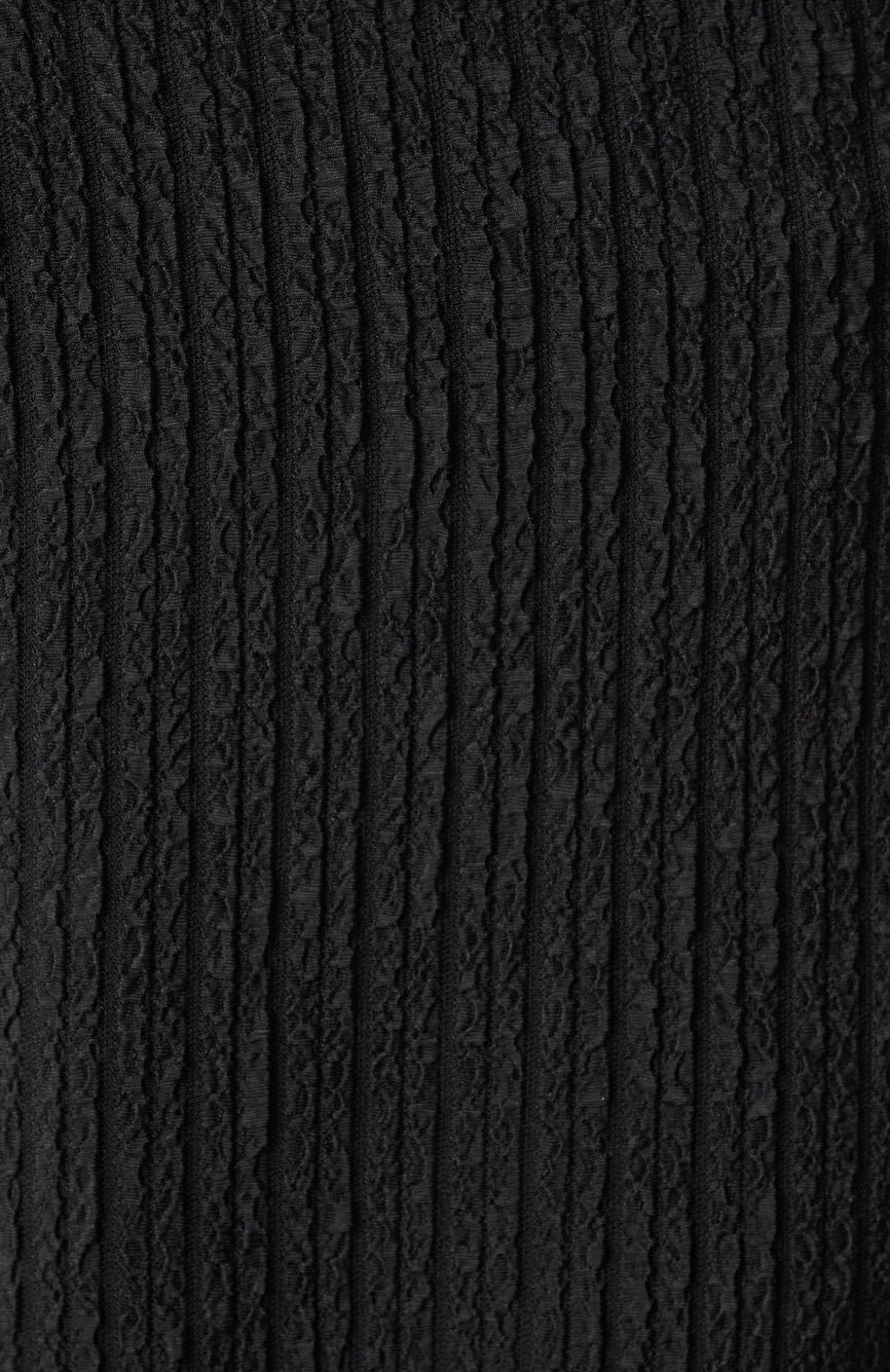 A close-up of a black textured fabric with a vertical ribbed and twisted cord-like pattern.