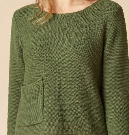 An olive green textured knit sweater with a crew neck and a front patch pocket, shown on a model against a warm beige background.