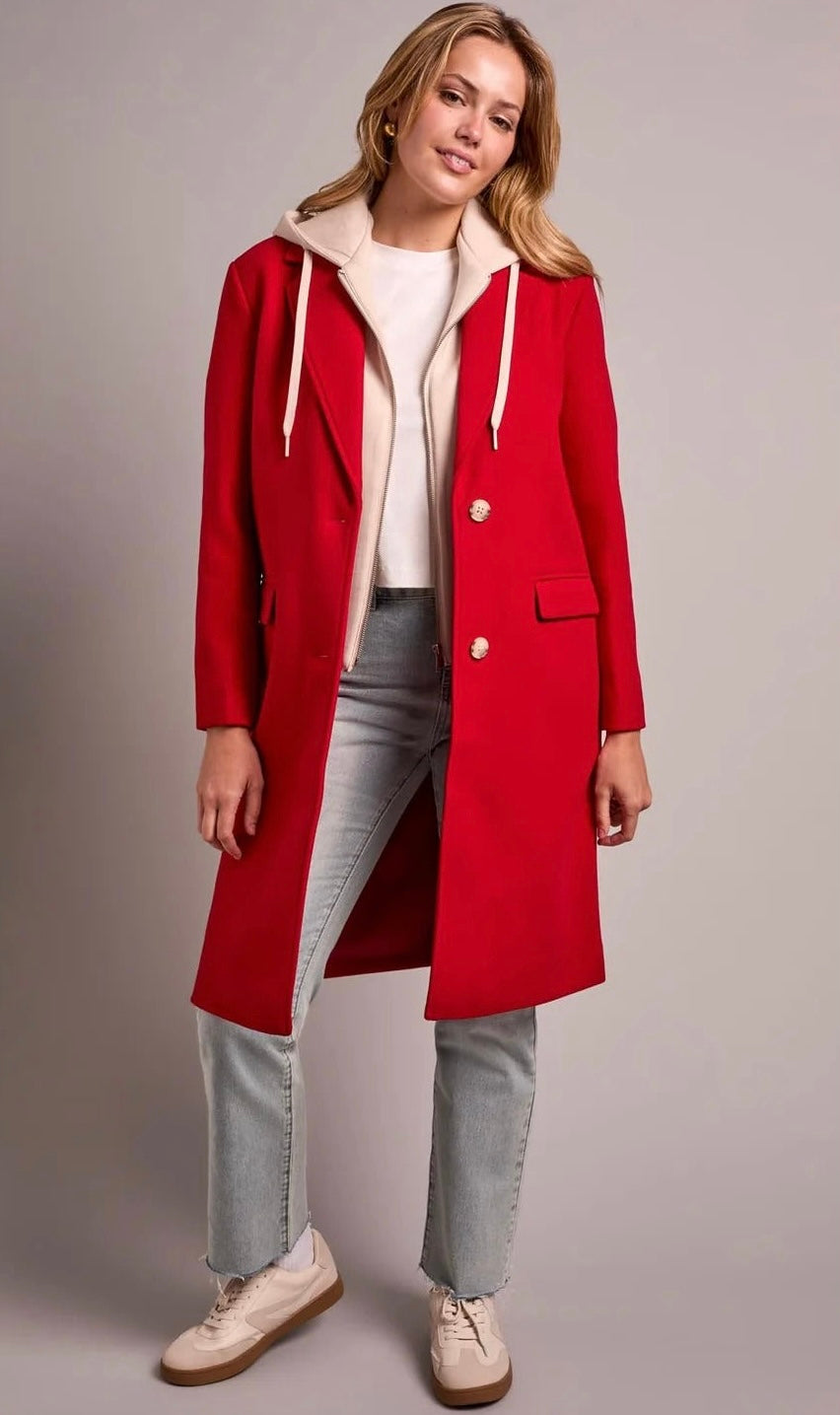 A woman models a bright red hooded coat with a cream-colored fleece-lined hood and gold-tone buttons, styled with a cream top, light-wash jeans, and beige sneakers against a neutral studio backdrop. -OLIVIA'S