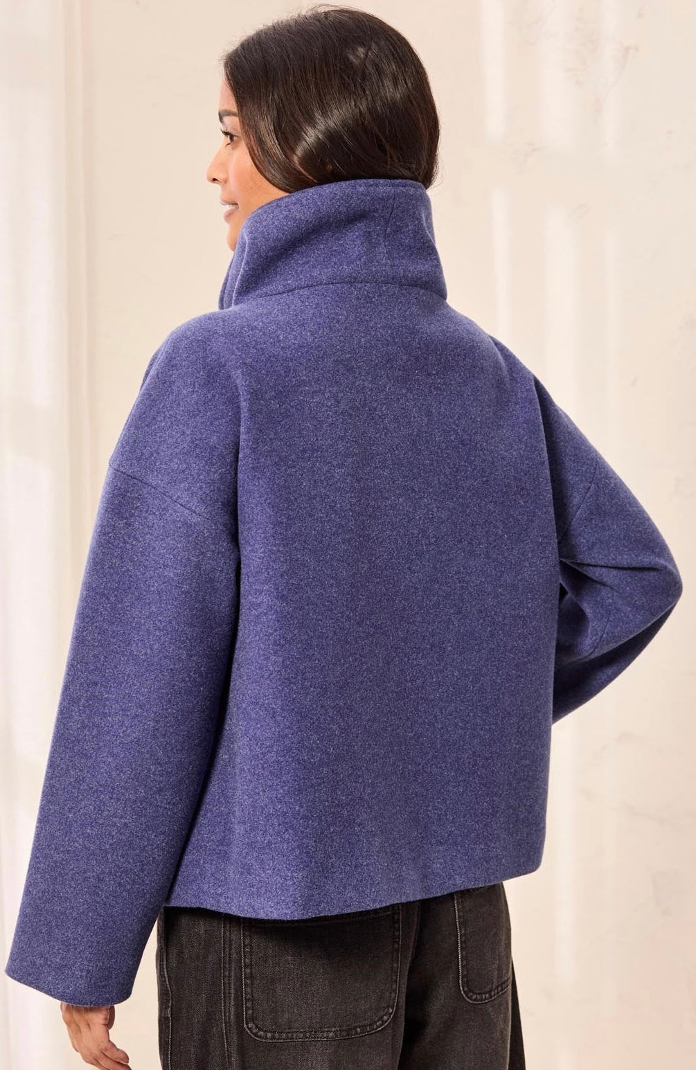 A woman shown from the back wearing a cropped, oversized high-neck coat in a heathered periwinkle blue color, paired with dark gray jeans. - OLIVIA'S