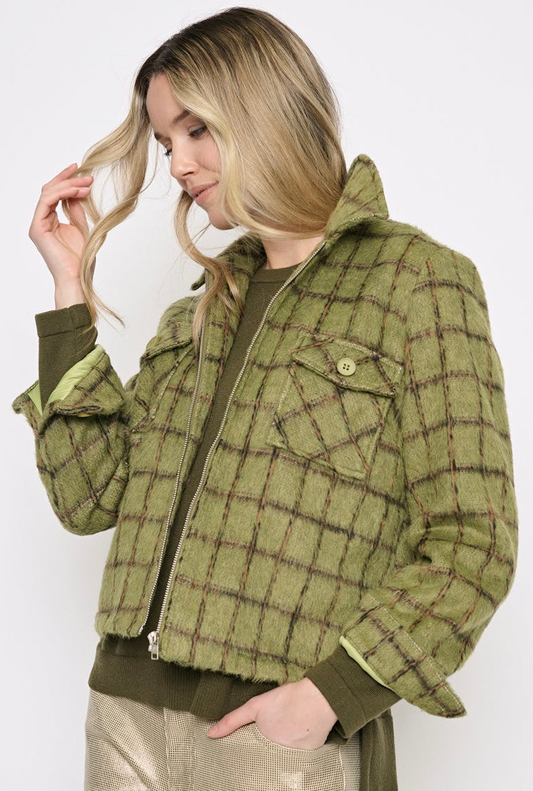 A woman wearing a cropped olive green plaid jacket with a zip front, button chest pocket, and ribbed cuffs, paired with metallic beige pants, against a plain white background. - OLIVIA'S