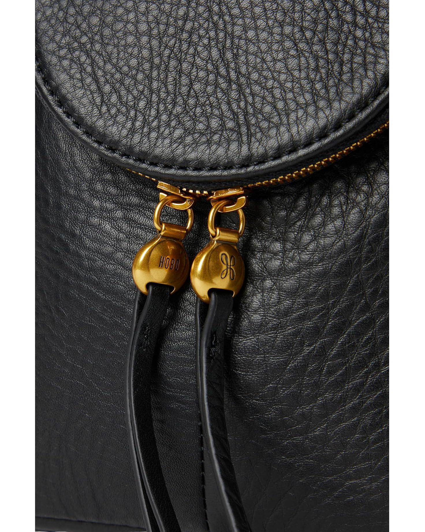 Close-up of a black leather bag with gold zipper pulls