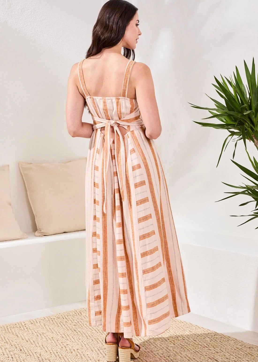 Woman wearing a striped dress in a minimal indoor setting