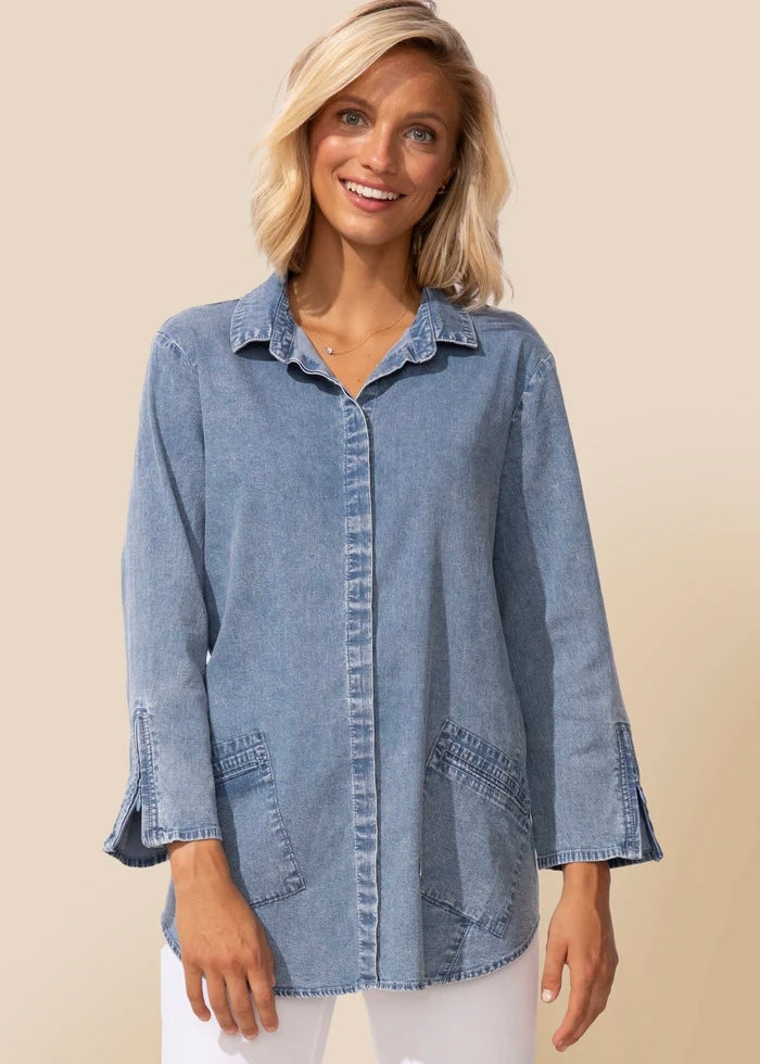 Woman wearing a denim shirt on a beige background