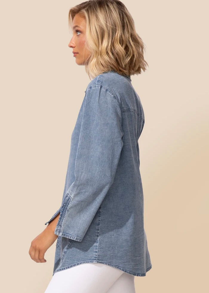 Woman wearing a denim shirt on a beige background