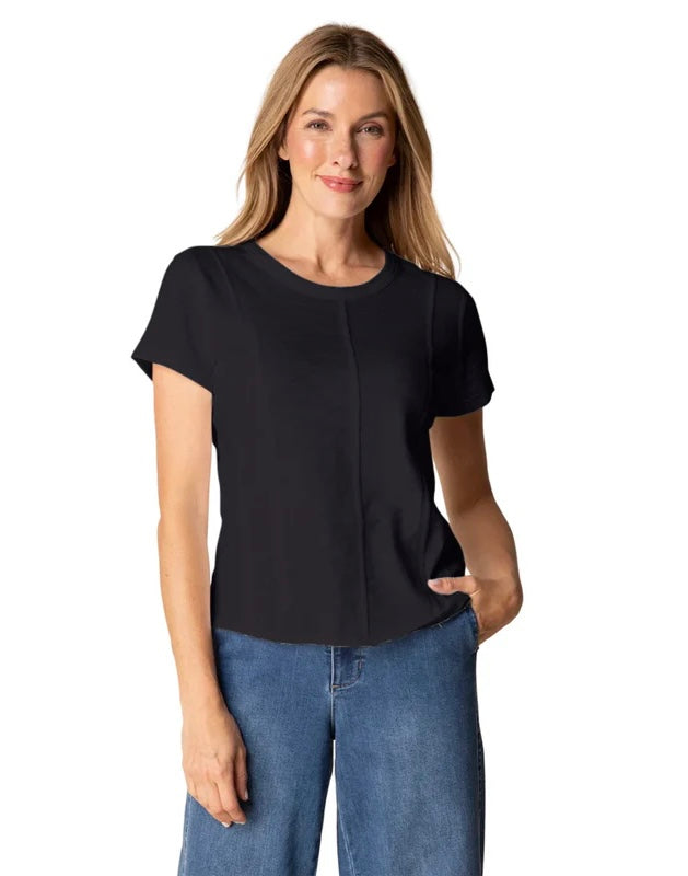 Woman wearing a black top and blue jeans on a white background