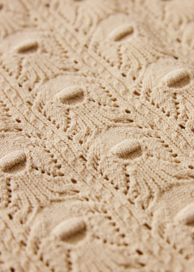 Close-up of textured beige fabric with a subtle pattern