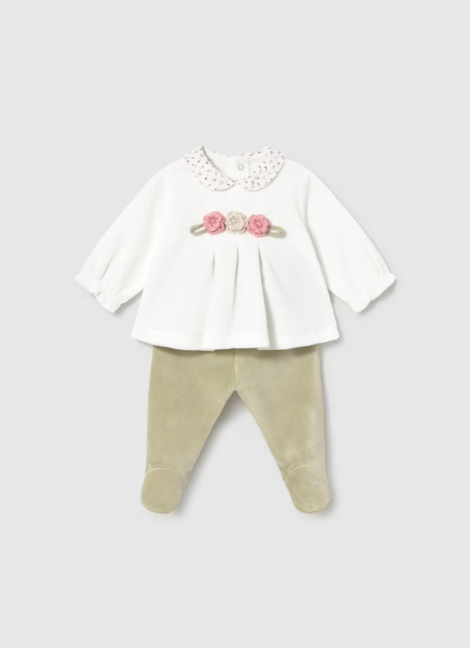 A baby girl's two-piece outfit featuring a white long-sleeve top with a lace Peter Pan collar and a pink floral chest detail, paired with beige footed pants, shown on a light gray background.