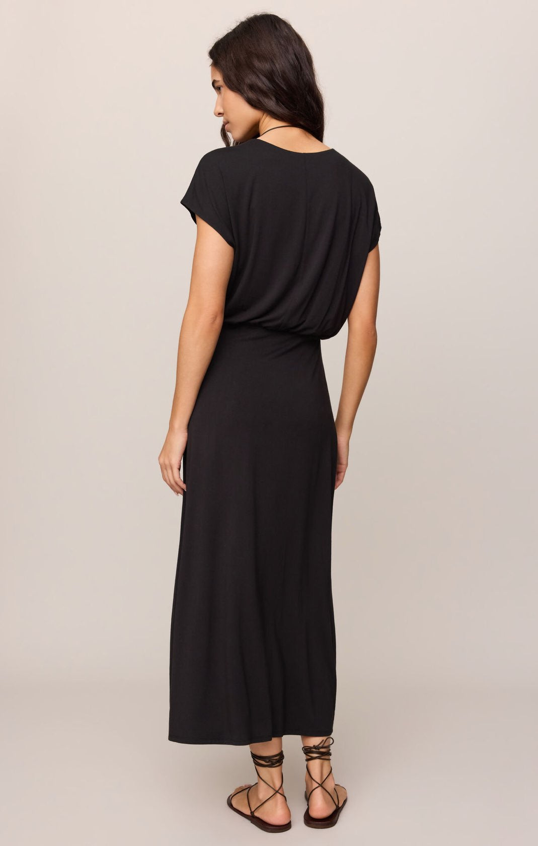 Woman wearing a black dress against a plain background