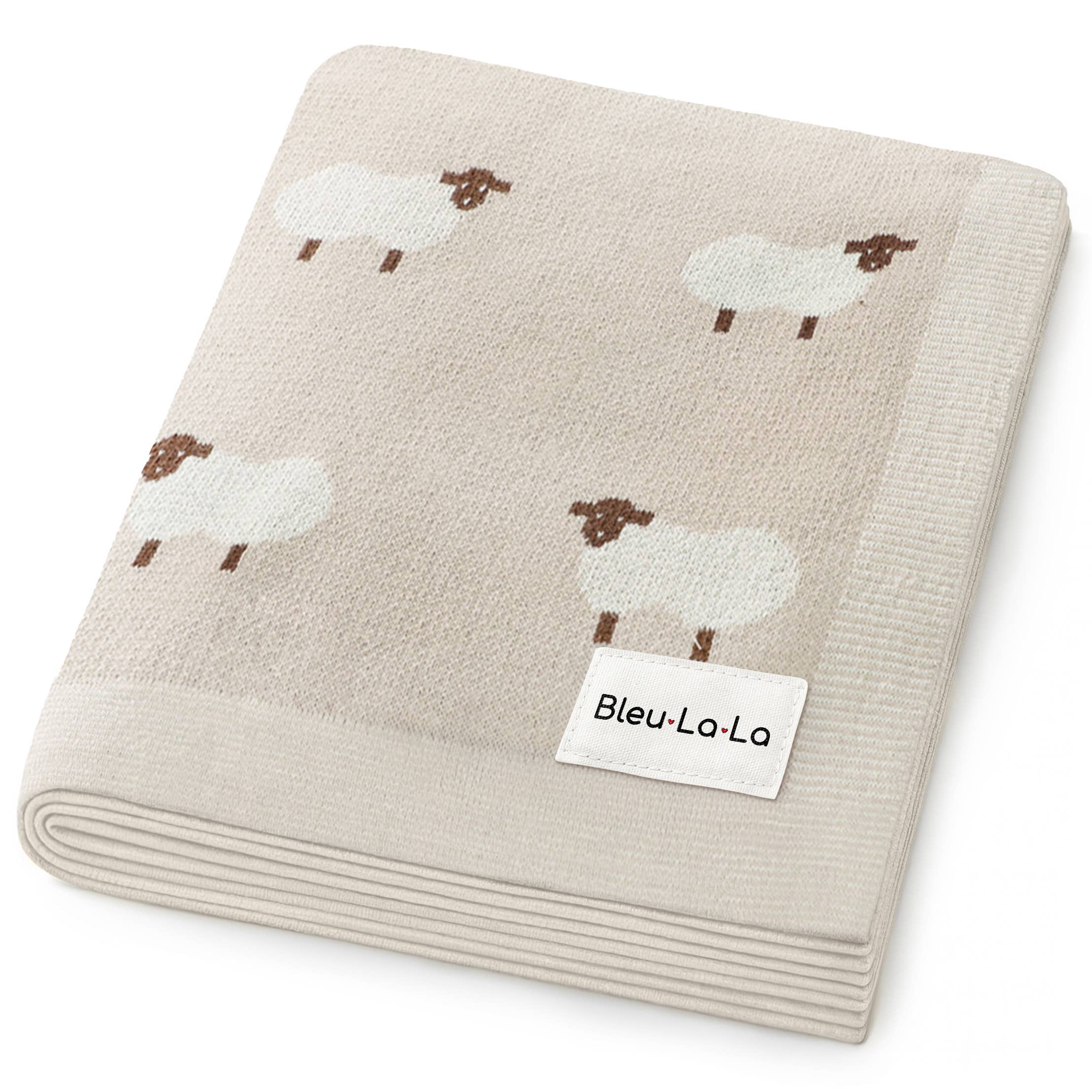 Folded beige blanket with sheep pattern and Bleu-La-La label on a white background