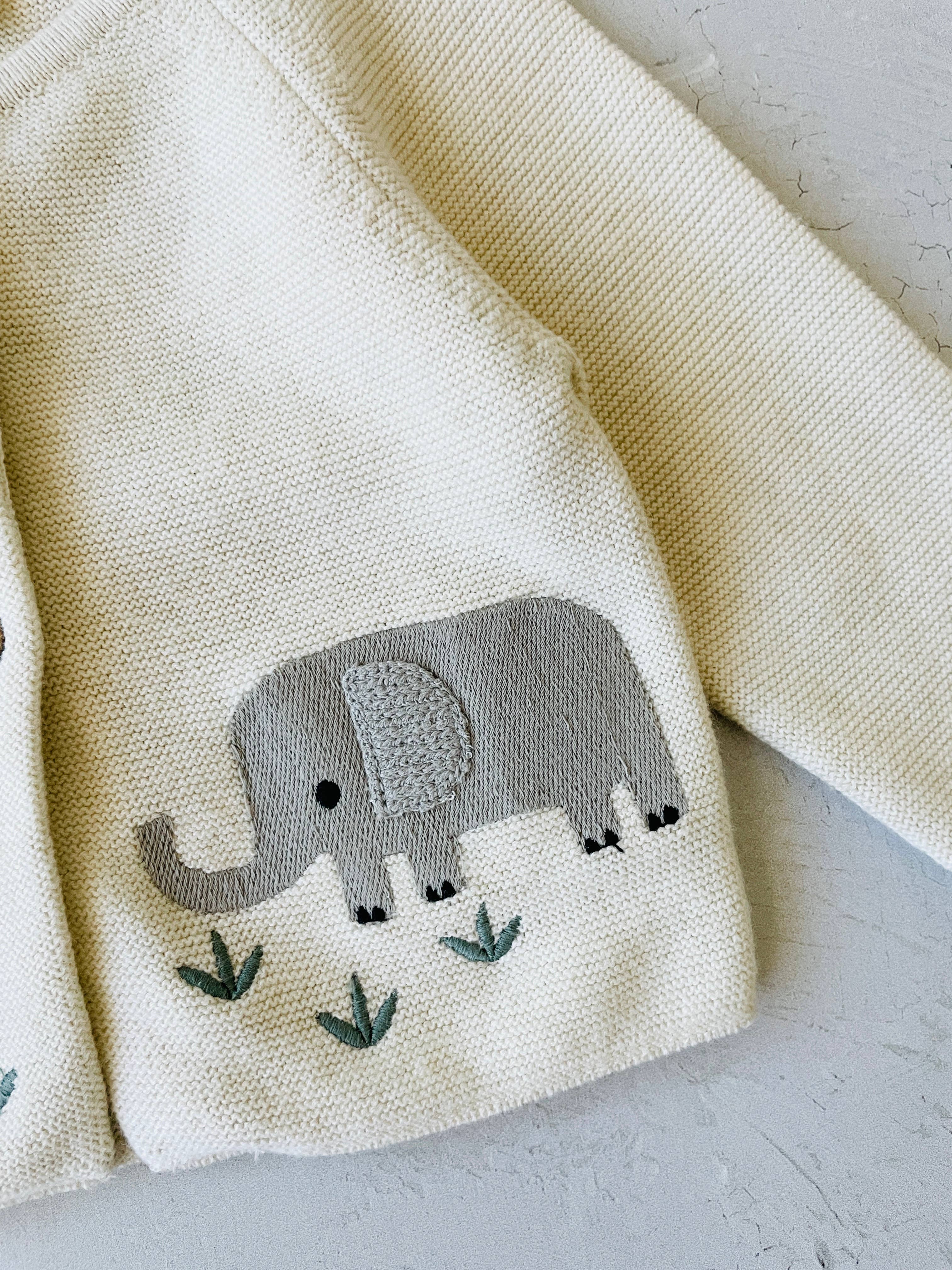 Beige fabric with an embroidered gray elephant design on a light gray background