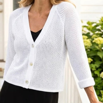 Habitat Sunburst Knit Cardigan in white, front view styled with black skirt, showing V-neck, pearl buttons, and open sunburst knit texture
