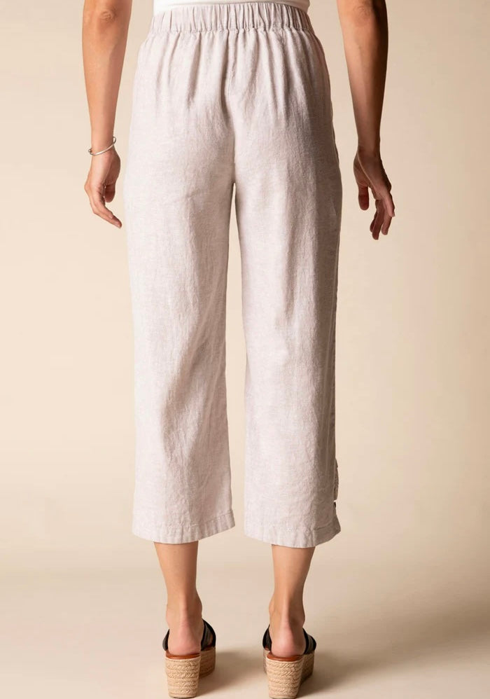 Front view (studio) — "Habitat Women's Linen Solid Pleat Button Capri in natural, front view showing pleat detail, side pockets, and cropped hem, styled with black platform wedge sandals"
Lifestyle shot — "Habitat Women's Linen Solid Pleat Button Capri in natural, full-length lifestyle shot on smiling curly-haired model styled with white floral shirt and black platform wedges, interior home setting"
Cropped front — "Habitat Women's Linen Solid Pleat Button Capri in natural, cropped front view highlighting p