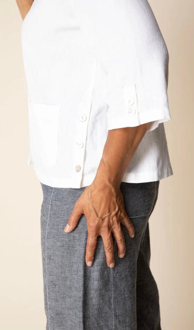 Front view (studio) — "Habitat Women's Favorite Camp Shirt in white linen, front view on smiling curly-haired model, V-neck collar, button front, patch pocket, and 3/4 sleeves, styled with grey linen trousers"
Back view — "Habitat Women's Favorite Camp Shirt in white linen, back view showing center pleat detail and relaxed fit, styled with grey linen trousers"
Side close-up — "Habitat Women's Favorite Camp Shirt in white linen, close-up side view highlighting button placket, side snap buttons, and hem detai