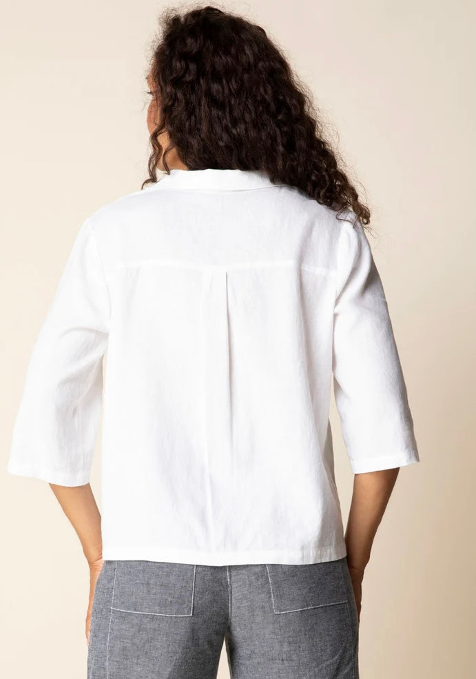 Front view (studio) — "Habitat Women's Favorite Camp Shirt in white linen, front view on smiling curly-haired model, V-neck collar, button front, patch pocket, and 3/4 sleeves, styled with grey linen trousers"
Back view — "Habitat Women's Favorite Camp Shirt in white linen, back view showing center pleat detail and relaxed fit, styled with grey linen trousers"
Side close-up — "Habitat Women's Favorite Camp Shirt in white linen, close-up side view highlighting button placket, side snap buttons, and hem detai