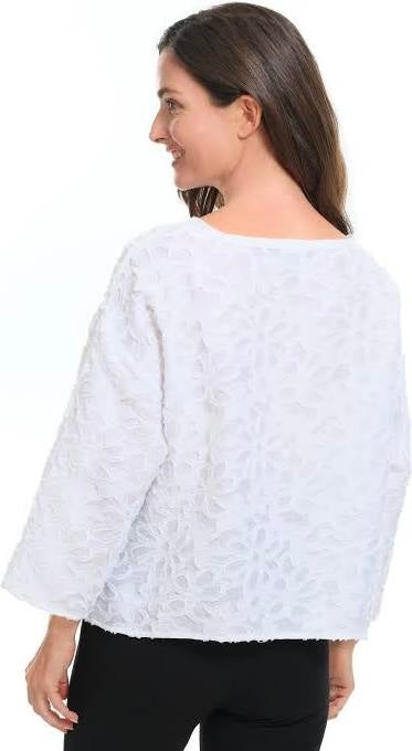White floral appliqué topper, back view showing textured fabric and relaxed fit, styled with black pants