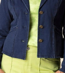 A cropped navy blue denim jacket with brown buttons, worn over a lime green top and matching green bottoms.