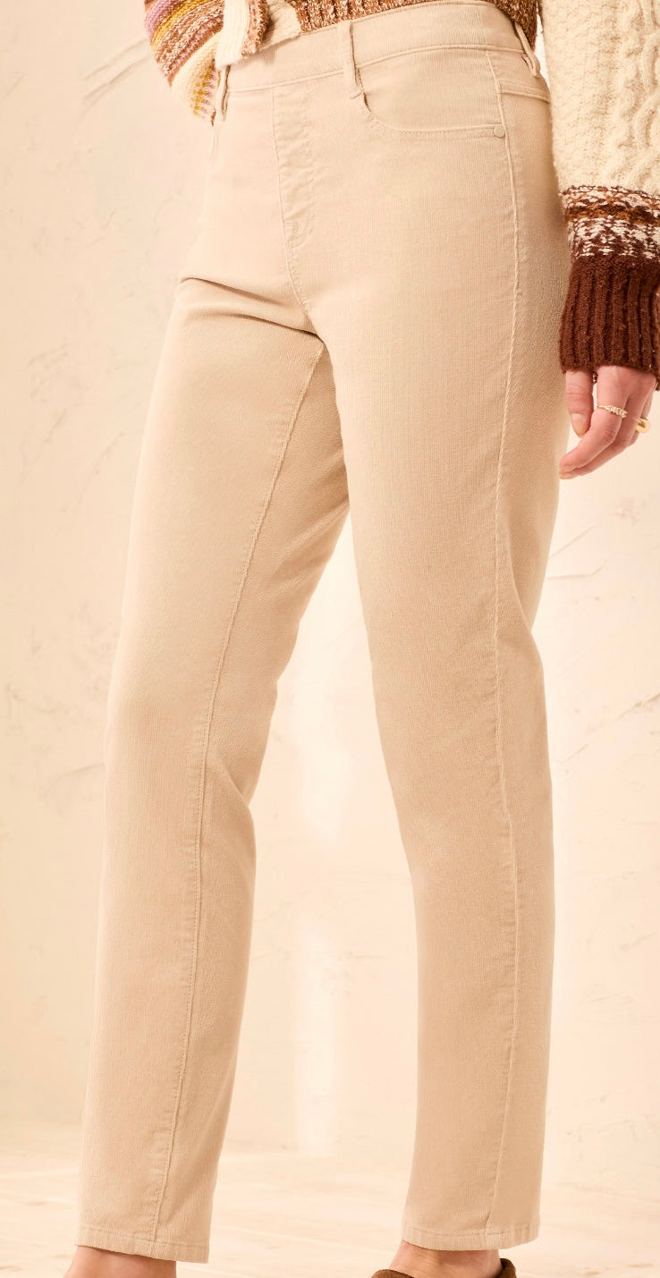 Beige straight-leg jeans shown on a model from the waist down, paired with a chunky knit sweater.