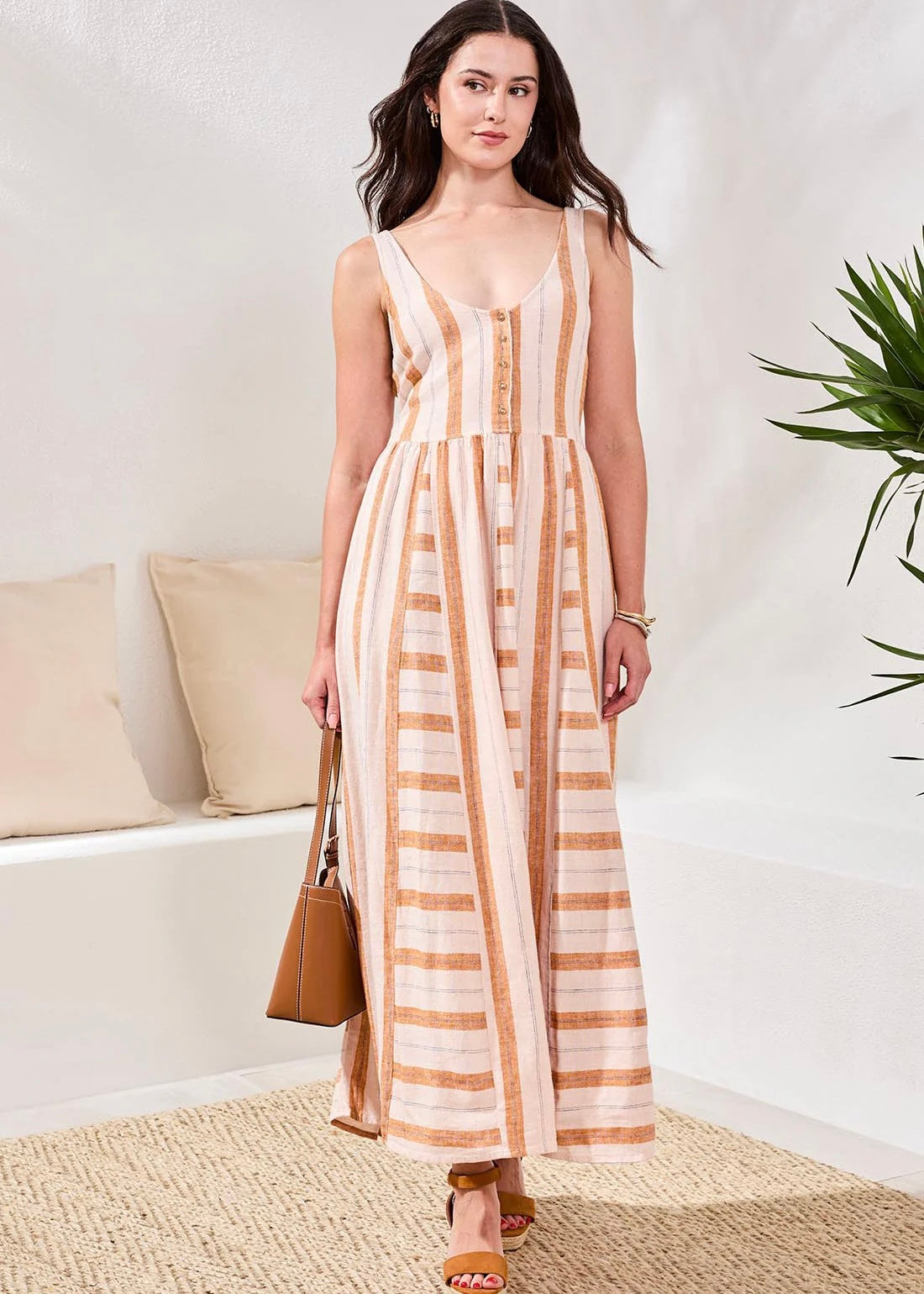 Woman wearing a striped dress in a minimal indoor setting