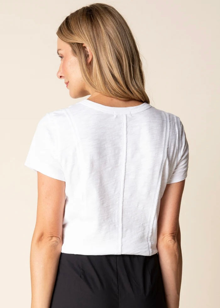 Woman wearing a white t-shirt with a beige background