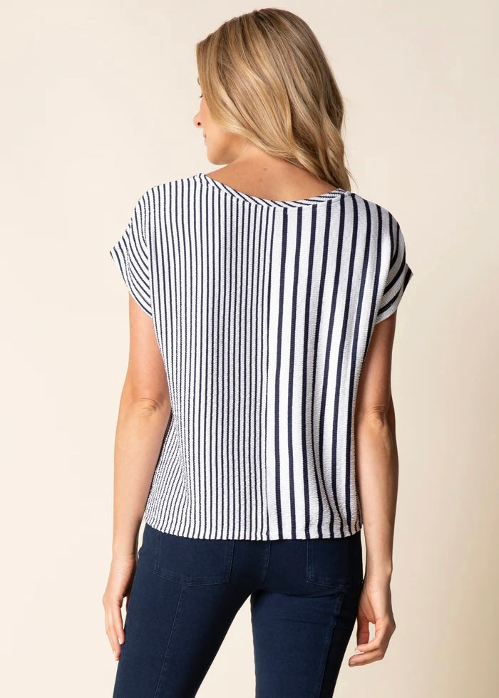 Woman wearing a black and white striped shirt against a beige background