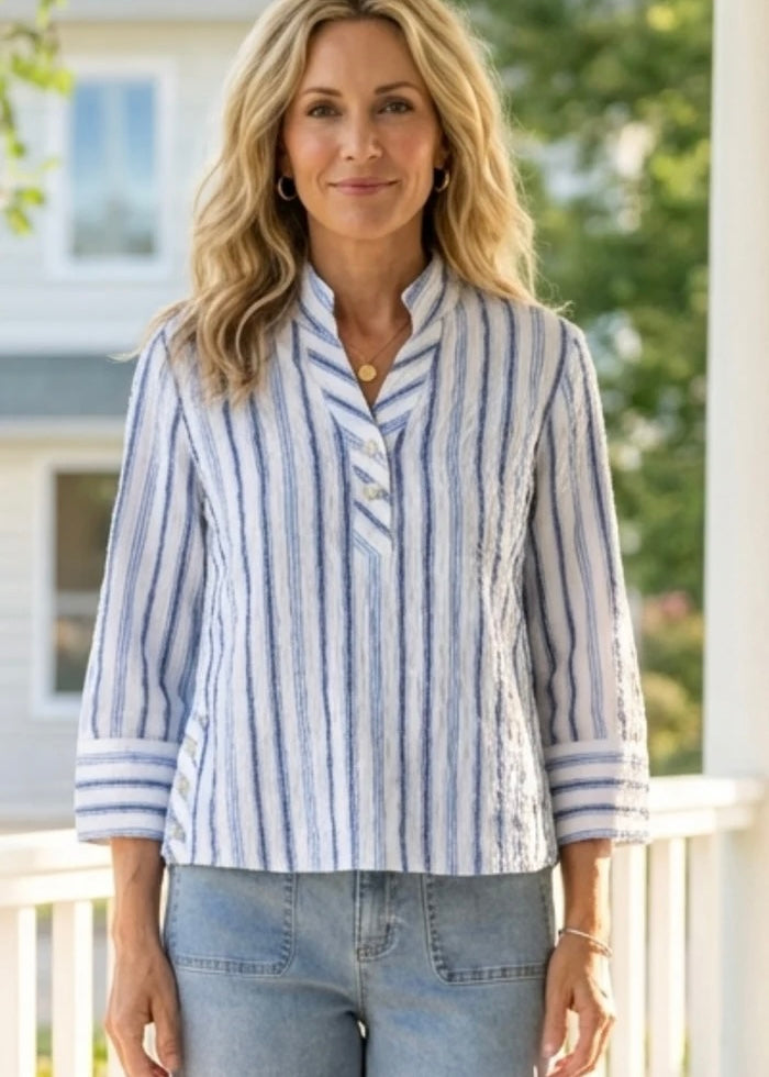 Woman wearing a blue and white striped shirt on a balcony