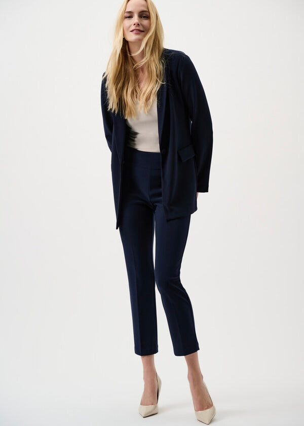 Woman wearing a navy suit with a white top on a white background