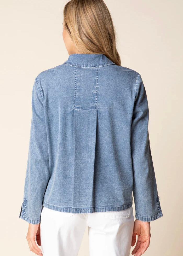 Woman wearing a blue denim jacket on a beige background