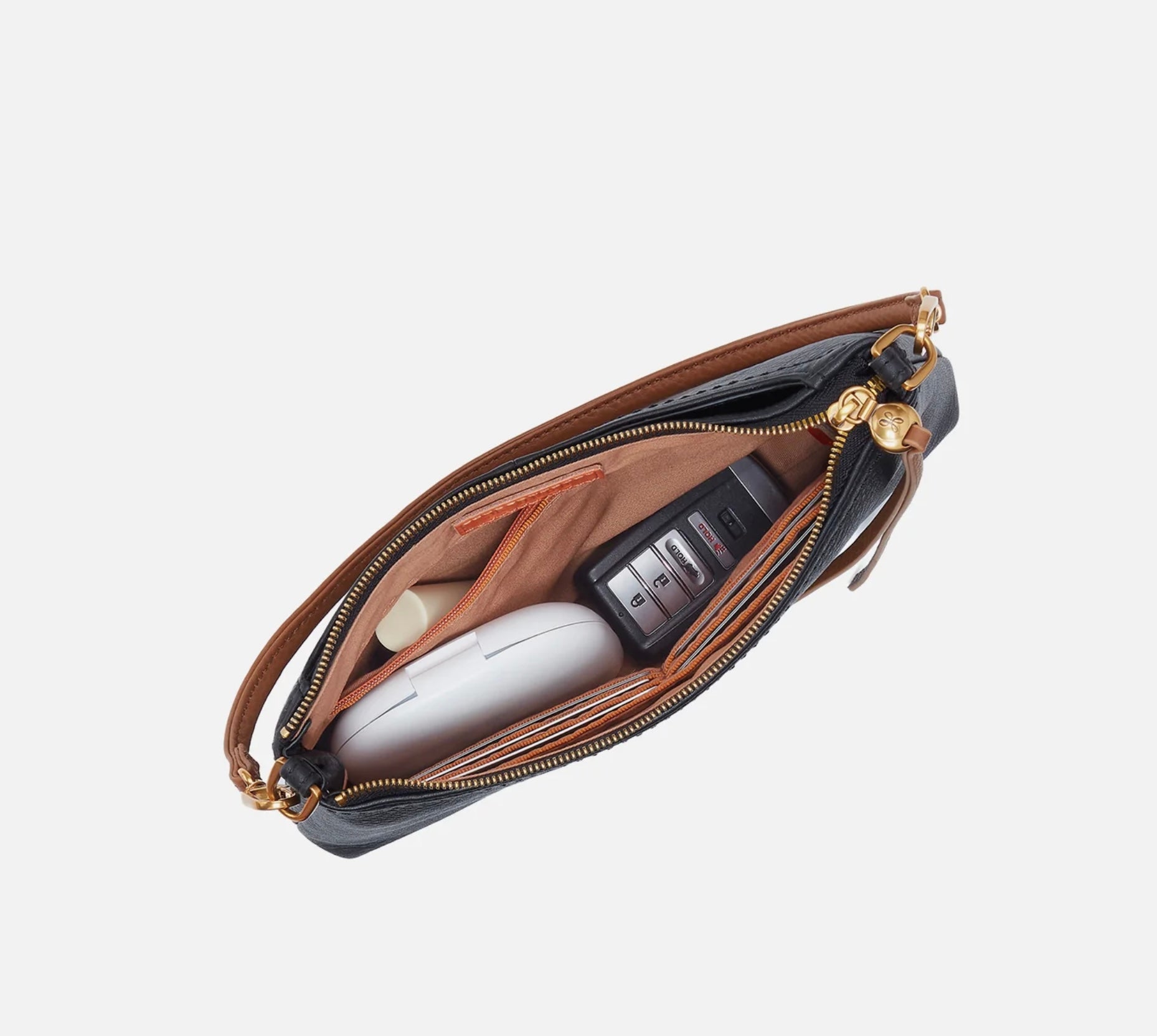 Open handbag with electronic devices on a light gray background