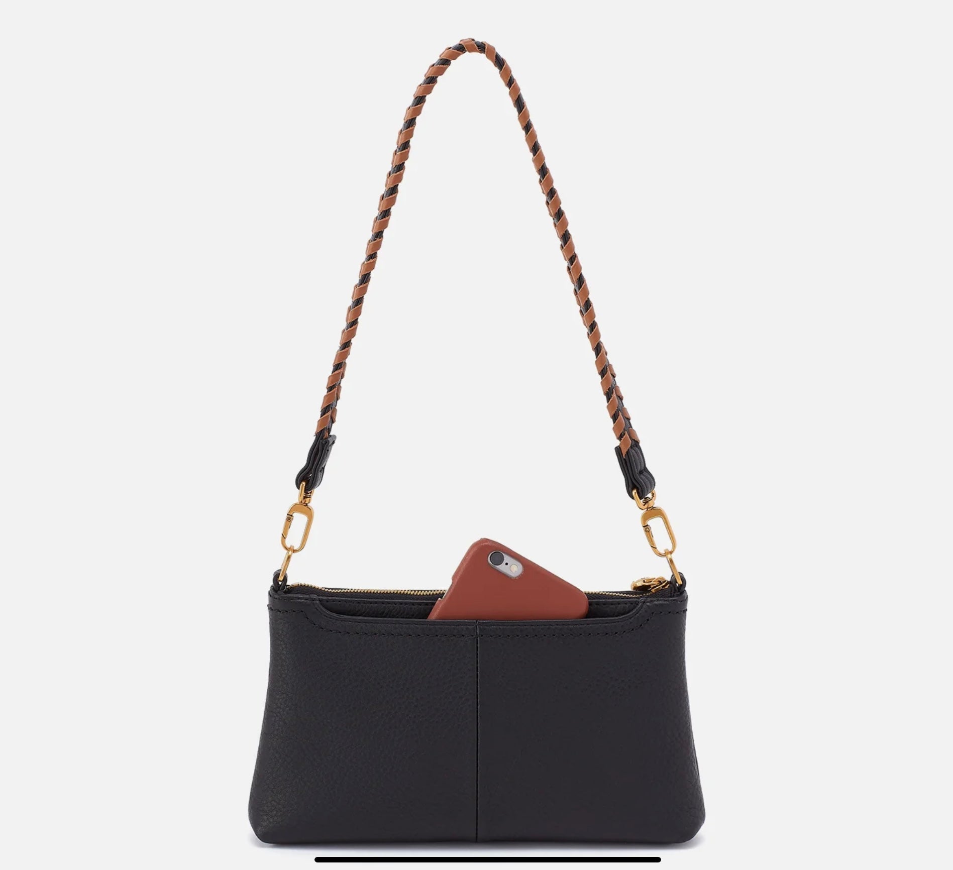 Black handbag with a brown phone case and braided strap on a light gray background