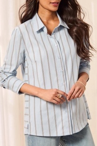 Woman wearing a light blue striped shirt against a beige background