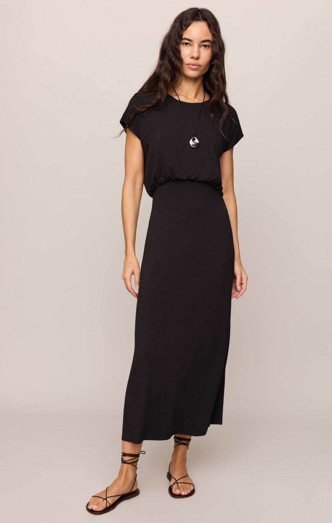 Woman wearing a black dress with a plain background