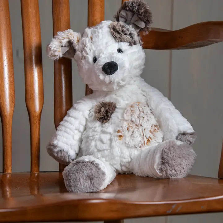 White and brown plush dog toy on a wooden chair